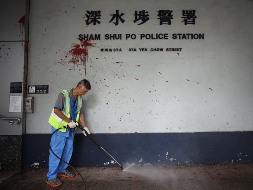 A worker cleans up the outside of Sham Shui Po Police Station after anti-government clashes. A worker cleans up the outside of Sham Shui Po Police Station after anti-government clashes.