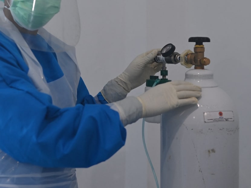 A nurse adjusting an oxygen tube at a hospital designated for Covid-19 in Indonesia.