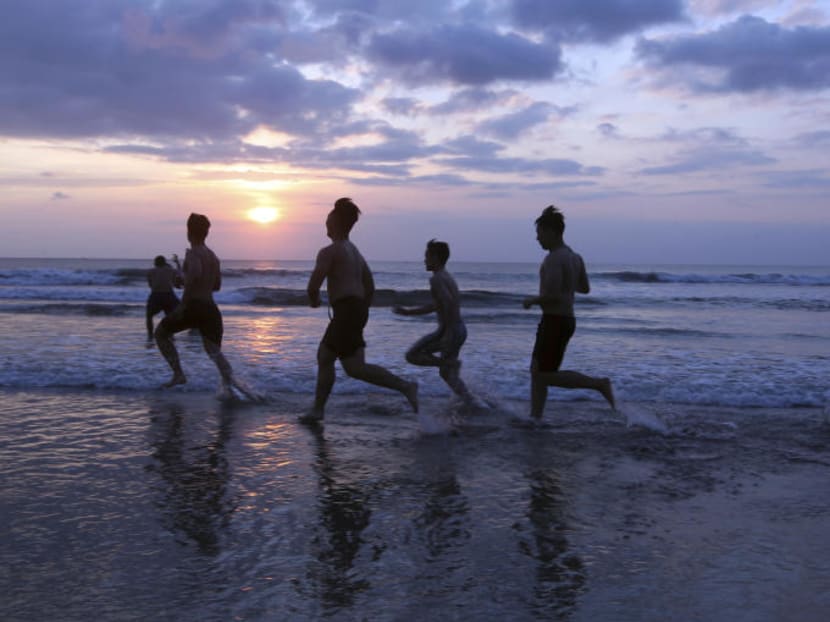 Tourists run on Kuta beach during sunset in Bali, Indonesia. Photo: AP
