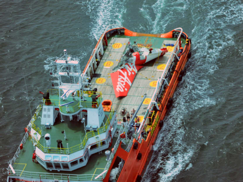 In this photo taken from an Indonesian Air Force Super Puma helicopter, the tail part of AirAsia QZ 8501 is seen on the deck of rescue ship Crest Onyx as it is being transported to Pangkalan Bun in Central Borneo, on the Java Sea, Sunday, Jan. 11, 2015. A day after the tail of the crashed AirAsia plane was fished out of the Java Sea, the search for the missing black boxes intensified Sunday with more pings heard. Photo: AP