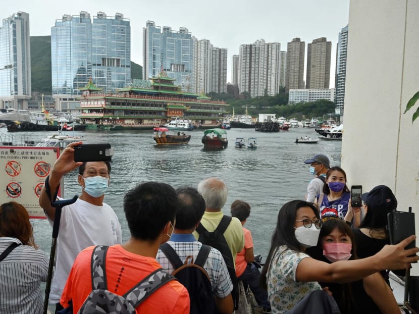 Onlookers taking photos as Hong Kong's Jumbo Floating Restaurant was towed out of Aberdeen Harbour on June 14, 2022.
