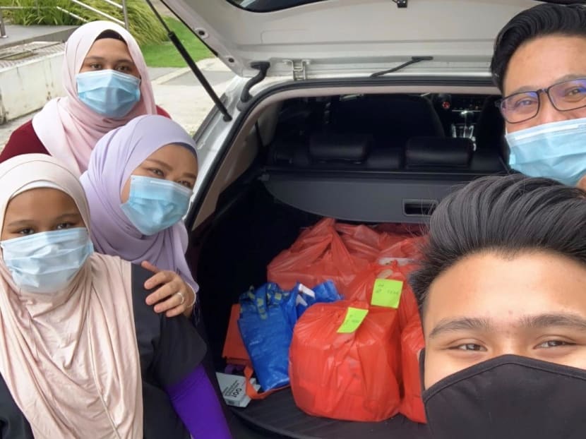 Mr Muhammad Wafiq Hadee Anuwar, 19, with his parents and sisters distributing packets of food on May 23, 2020. Mr Muhammad Wafiq Hadee Anuwar, 19, with his parents and sisters distributing packets of food on May 23, 2020.