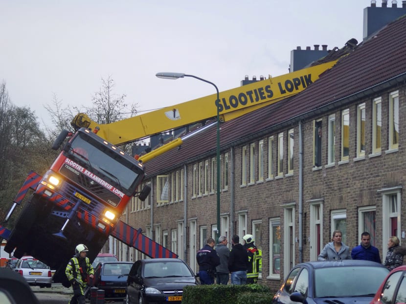 A crane which crashed into the roof of a house is seen following an unusual marriage proposal by a man who wished to be lifted in front of the bedroom window of his girlfriend to ask for her hand in marriage, in the central Dutch town of IJsselstein on Dec 13, 2014. Photo: AP/AS Media