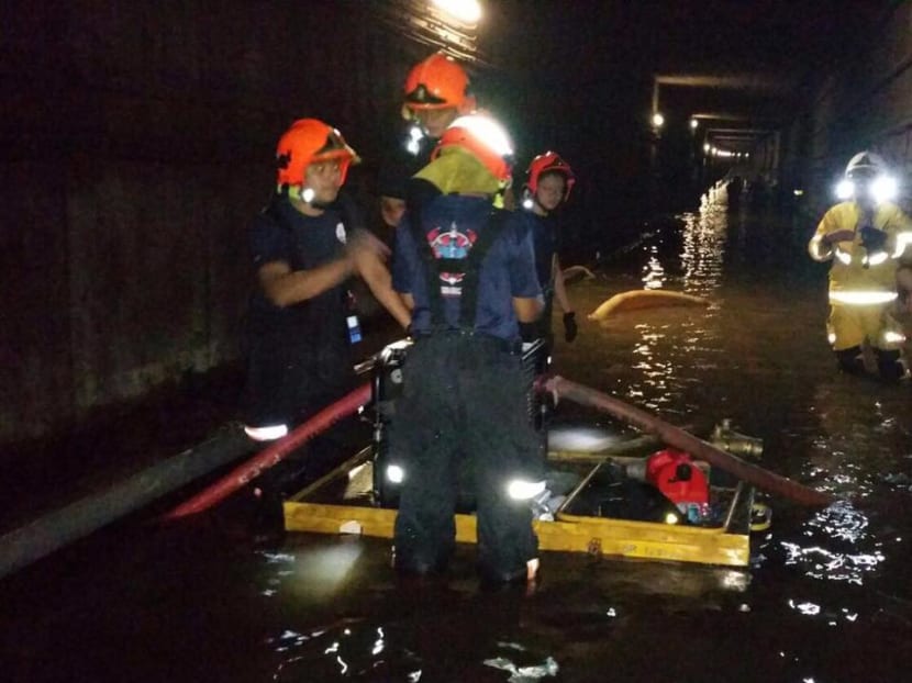 SCDF personnel work to clear a flooded tunnel between Braddell and Bishan MRT stations. SCDF said that at approximately 11am on Sunday, the water in the tunnels had been completely cleared. Photo: SCDF