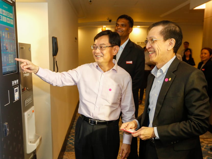 Deputy Prime Minister Heng Swee Keat (left) on Feb 25, 2020 looking at the vending machine and ice dispenser that Parkroyal on Kitchener Road has installed to replace minibars in individual hotel rooms