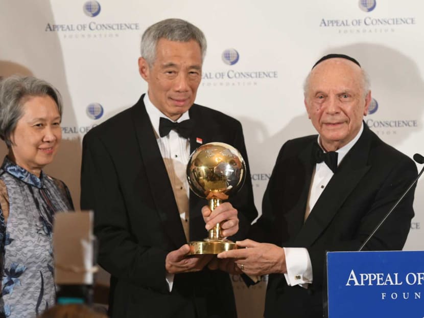Prime Minister Lee Hsien Loong, accompanied by his wife Ho Ching, receiving the World Statesman Award from Rabbi Arthur Schneier, the founder of the Appeal of Conscience Foundation.