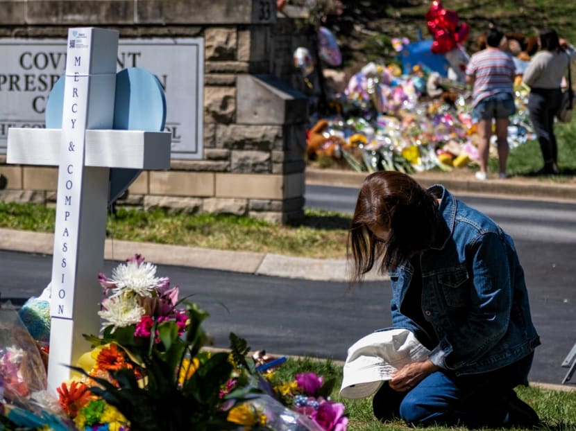 A woman prays at a makeshift memorial for those killed in a mass shooting at the entrance of The Covenant School on March 29, 2023 in Nashville, Tennessee.