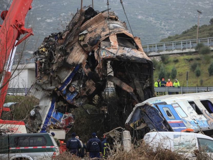 A crane lifts part of a destroyed carriage as rescuers operate on the site of a crash, where two trains collided, near the city of Larissa, Greece, March 2, 2023. REUTERS/Kostas Mantziaris