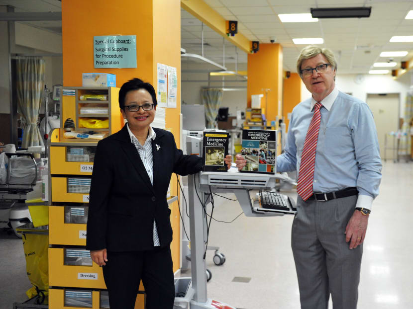 Associate Professor Shirley Ooi and Associate Professor Peter Manning holding the first and second editions of Guide to the Essentials In Emergency Medicine at the Emergency Medicine Department of the National University Hospital. Photo: NUS Yong Loo Lin School of Medicine
