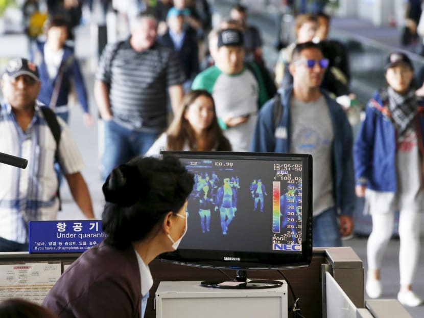 Passengers wearing masks to prevent contracting Middle East Respiratory Syndrome (MERS) walk past a thermal imaging camera at Incheon International Airport in Incheon, South Korea, June 2, 2015. Photo: Reuters
