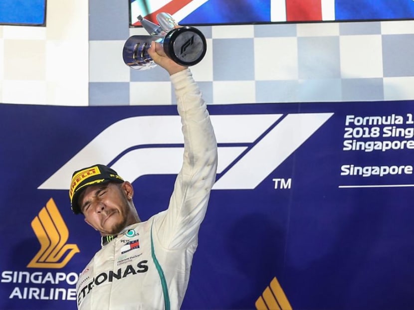 Britain's Lewis Hamilton celebrates on the podium after winning the race. It was the Mercedes driver's fourth Singapore Grand Prix victory.