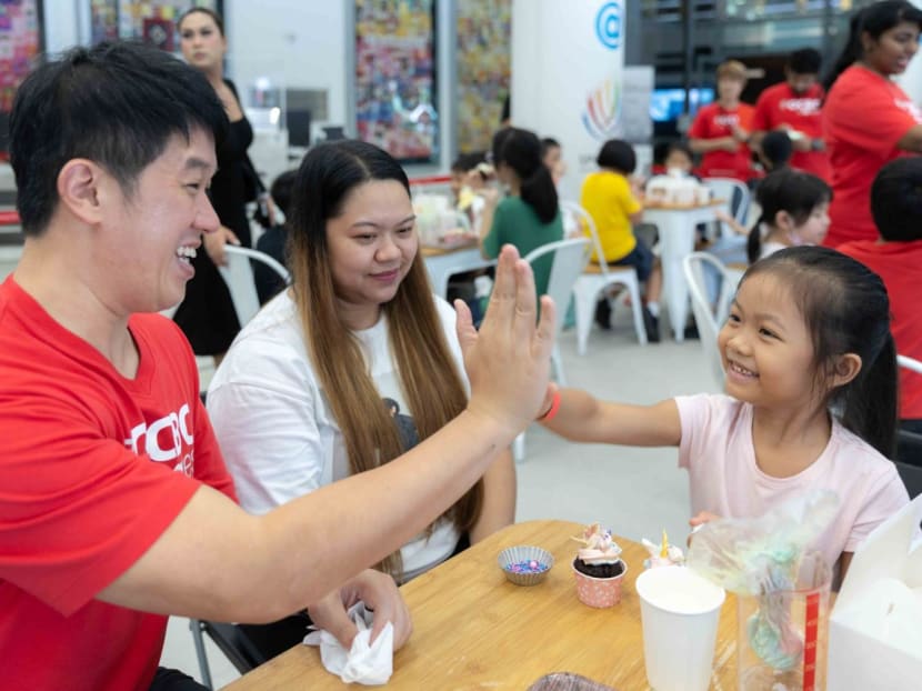 Volunteer Keeve Tan (left), a managing director with OCBC bank, interacting with six-year-old Macey Sumitha Manivannan (right) from one of the beneficiary families, at the Families100 Programme launch event on May 22, 2023.