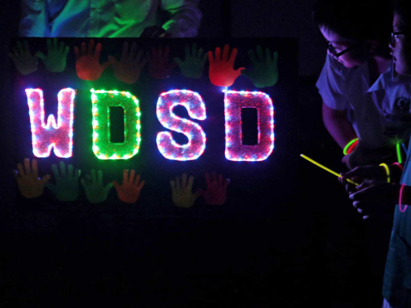 Students of MINDS Fernvale Gardens School and Fernvale Primary school wearing glow-in-the-dark wristbands during a special celebration to commemorate Word Down Syndrome Day on March 21, 2017. Photo: Jason Quah/TODAY