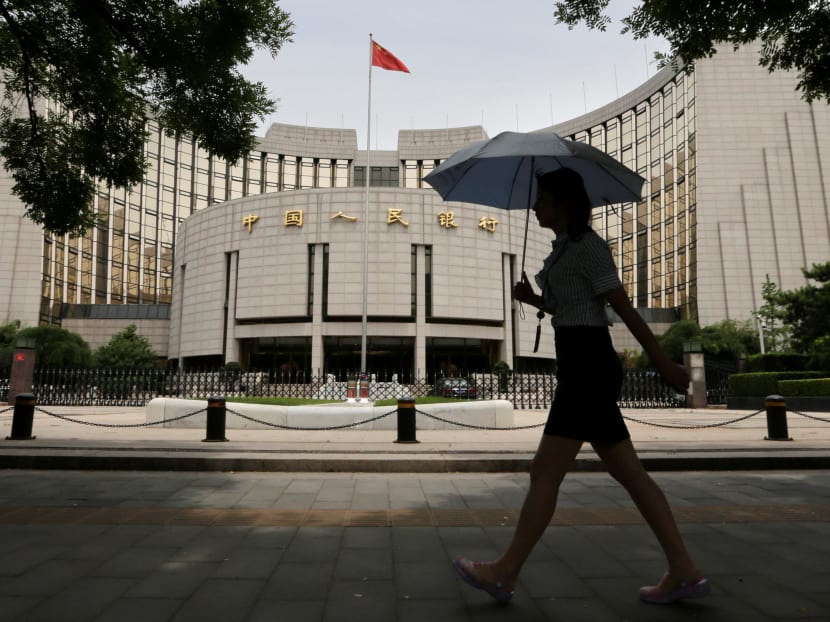 A woman walks past the headquarters of the People's Bank of China (PBOC), the central bank, in Beijing. Optimism about China’s economic growth in 2018 is not warranted, but this does not mean that China’s prospects are altogether dismal, says the author. Photo: Reuters