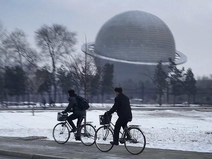 In this Feb 23, 2016, file photo, North Koreans cycle past a planetarium at the Three Revolutions Exhibition Hall in Pyongyang, North Korea. Photo: AP