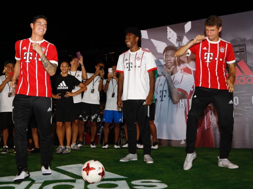 FC Bayern Munich players Thomas Muller (right) and James Rodriguez (left) dance, while David Alaba (centre) looks on before a football freestyle challenge at Clifford Square on Monday. Photo: Raj Nadarajan