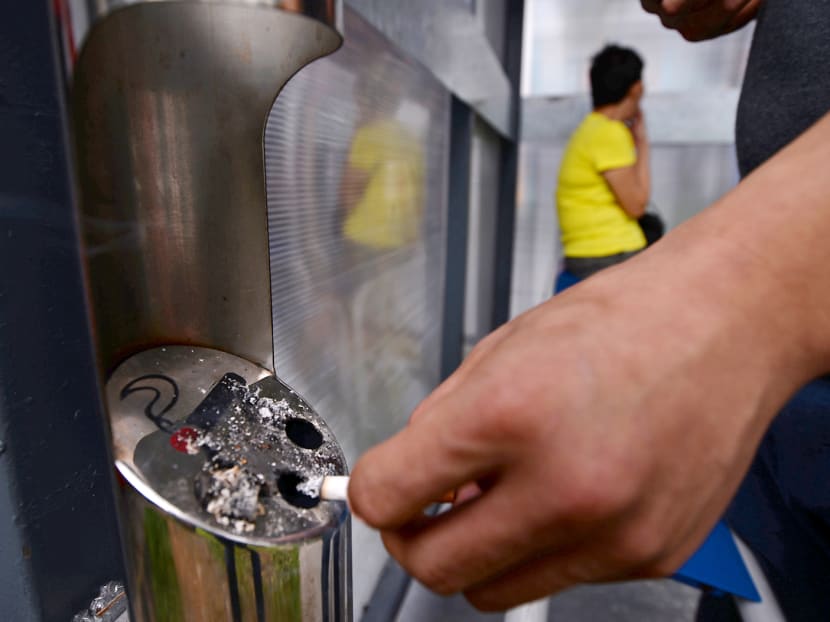A smoker disposing his cigarette butt at one of the 50 Designated Smoking Points located around Nee Soon South. Photo: Robin Choo