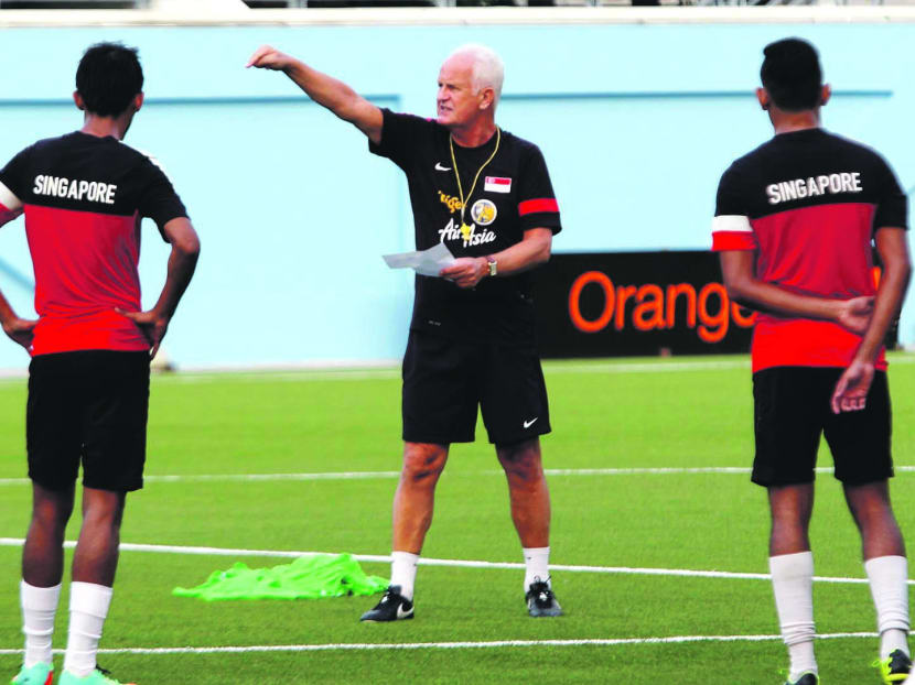 Singapore coach Bernd Stange (centre) and the Lions at training yesterday. The national coach promised that the Lions will not sit back against the much stronger Jordan side. Photo: WEE TECK HIAN