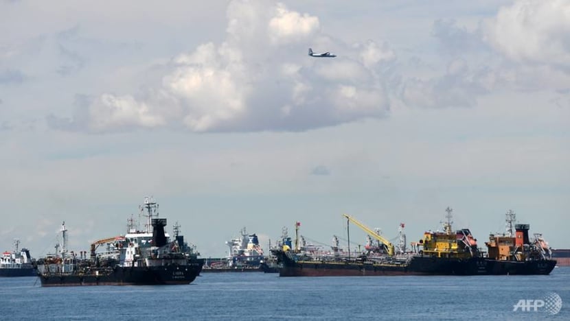 a plane flies over sea vessels anchored off the eastern anchorage in singapore on july 17 2020