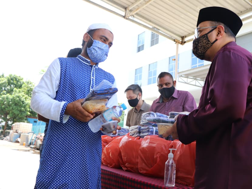 Ustaz Mohammad Hannan Hassan (right) distributing food and gifts to foreign workers during Hari Raya Puasa celebrations on May 13, 2021.
