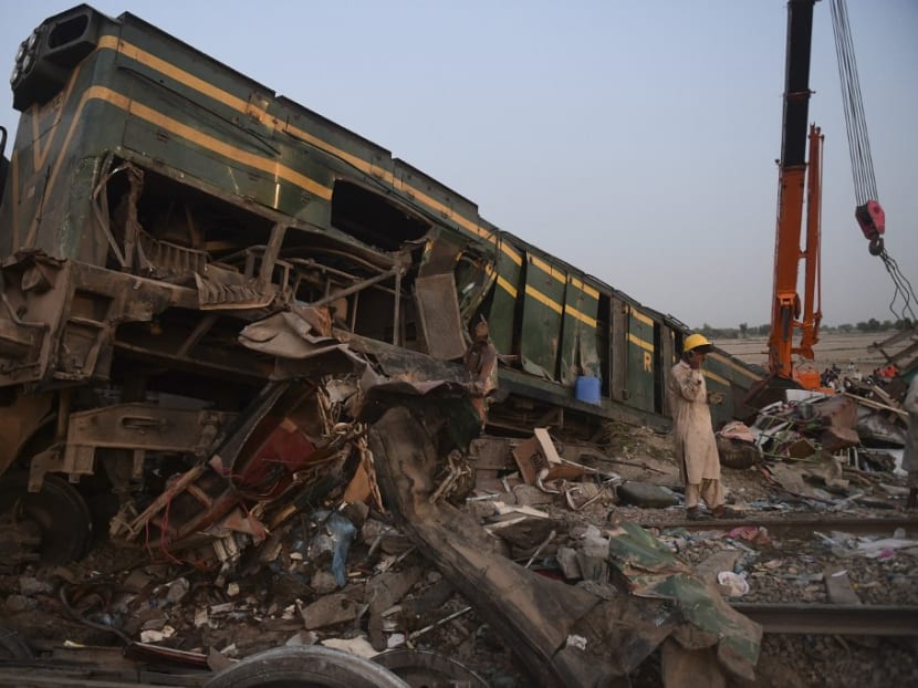 A railway worker stands at the site of a train accident in Daharki area of the northern Sindh province on June 7, 2021, as at least 43 people were killed and dozens injured when a packed Pakistani inter-city train ploughed into another express that had derailed just minutes earlier, officials said.