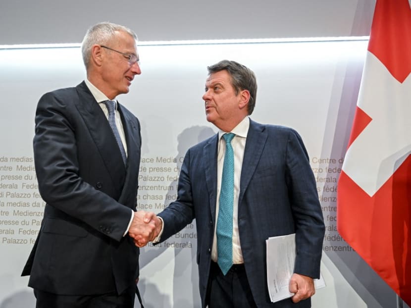 UBS Chairman Colm Kelleher (R) shakes hands with Credit Suisse chairman Axel Lehmann (L) after a press conference following talks over Credit Suisse in Bern on March 19, 2023. 