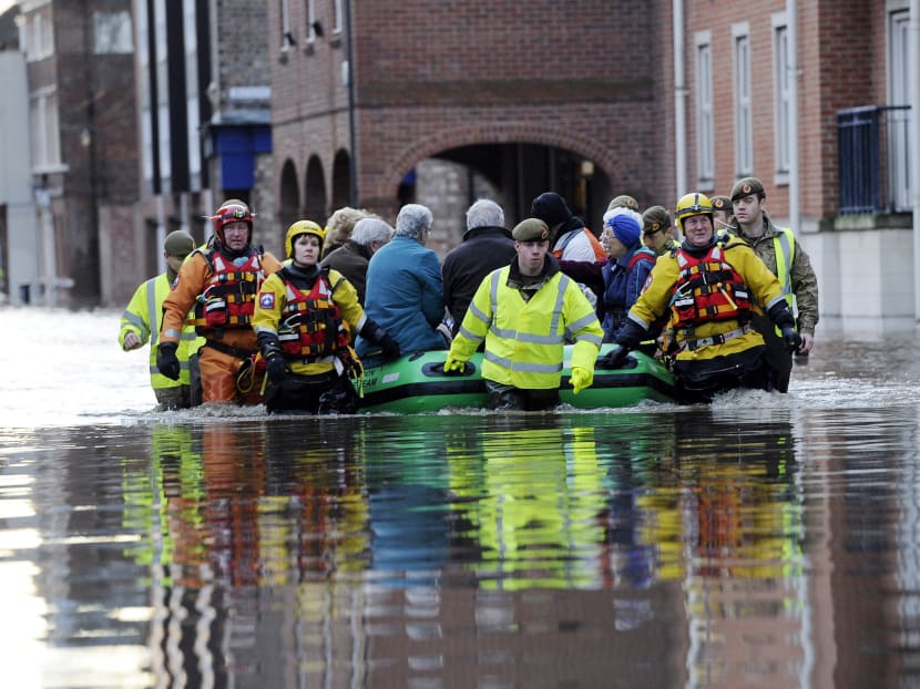 Members of the Army and rescue teams help evacuate people from flooded properties after they became trapped by rising floodwater when the River Ouse bursts its banks in York city centre on Dec 27, 2015. Photo: AP