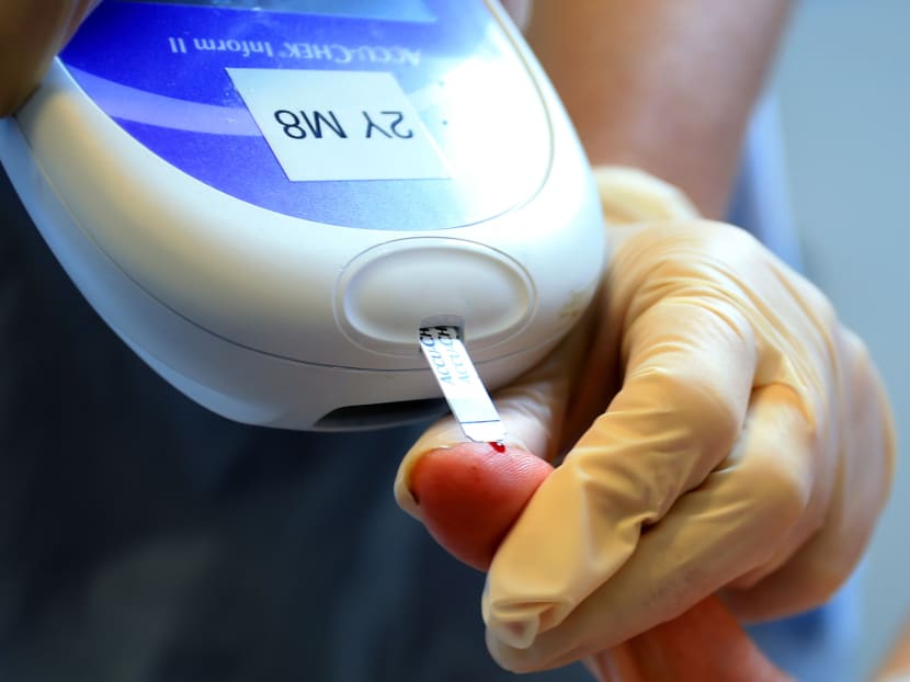 A nurse giving a patient a diabetes test. A nurse giving a patient a diabetes test.