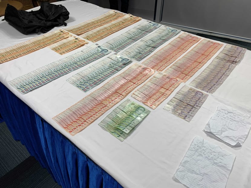 Cash, two handwritten notes and a bag that were seized by the police in relation to a robbery at Bukit Batok Street 31 on July 8, 2021.