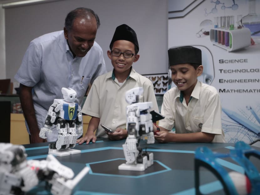 Minister K Shanmugam watches as madrasah students play with a robot on March 30, 2016. Photo: Jason Quah