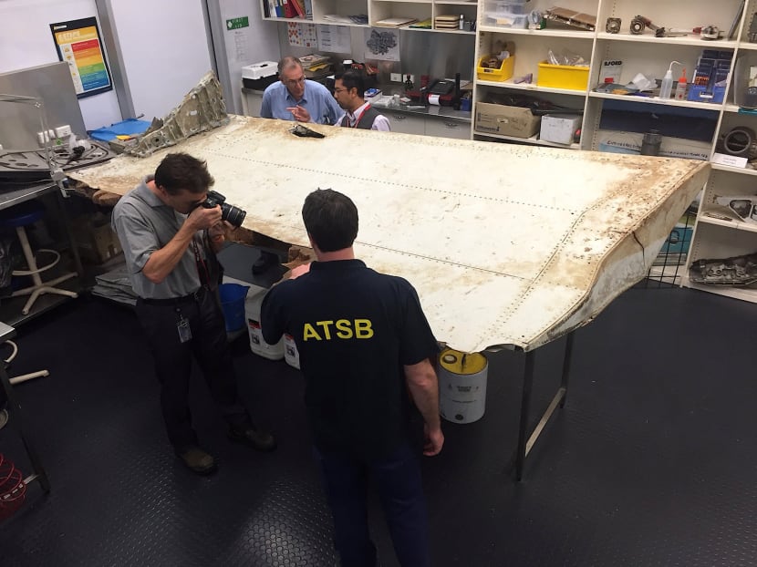 Australian and Malaysian officials examine aircraft debris at the Australian Transport Safety Bureau headquarters in Canberra, Australia, July 20, 2016 after it was found on Pemba Island, near Tanzania, in late June. Photo: Australian Transport Safety Bureau/Handout via Reuters
