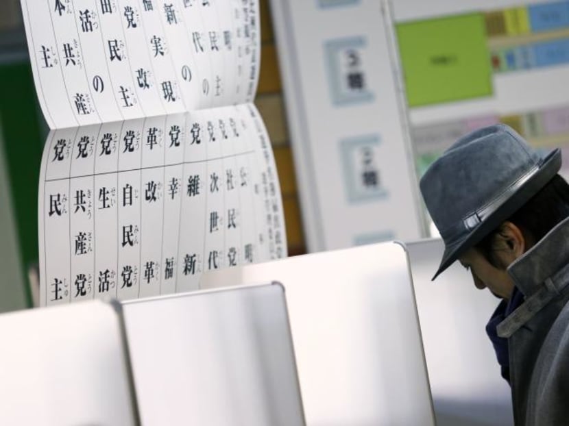A man fills his ballot paper to vote in the lower house parliamentary election in Tokyo. Photo: Reuters