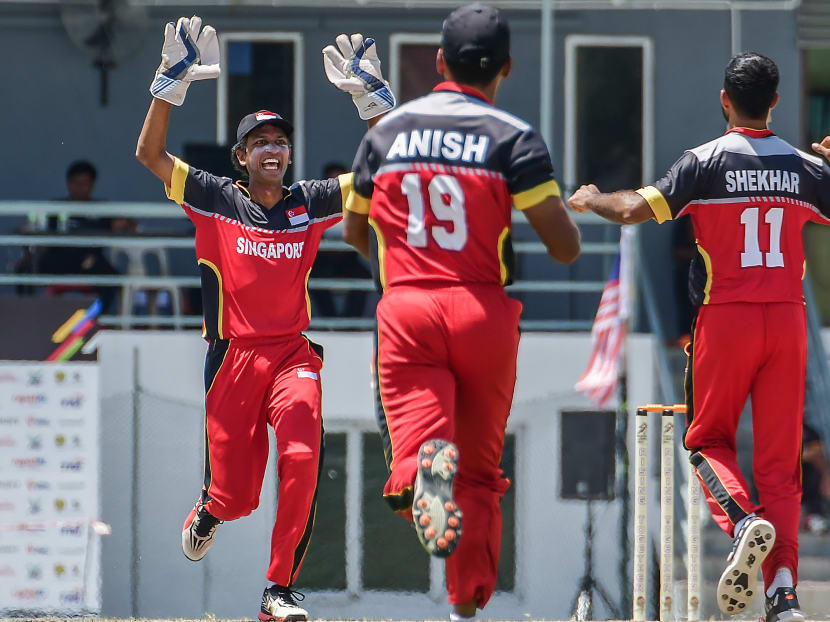 Singapore's players celebrate as another Malaysian batsman is bowled out. Photo: AndrewJKTan/SportSG