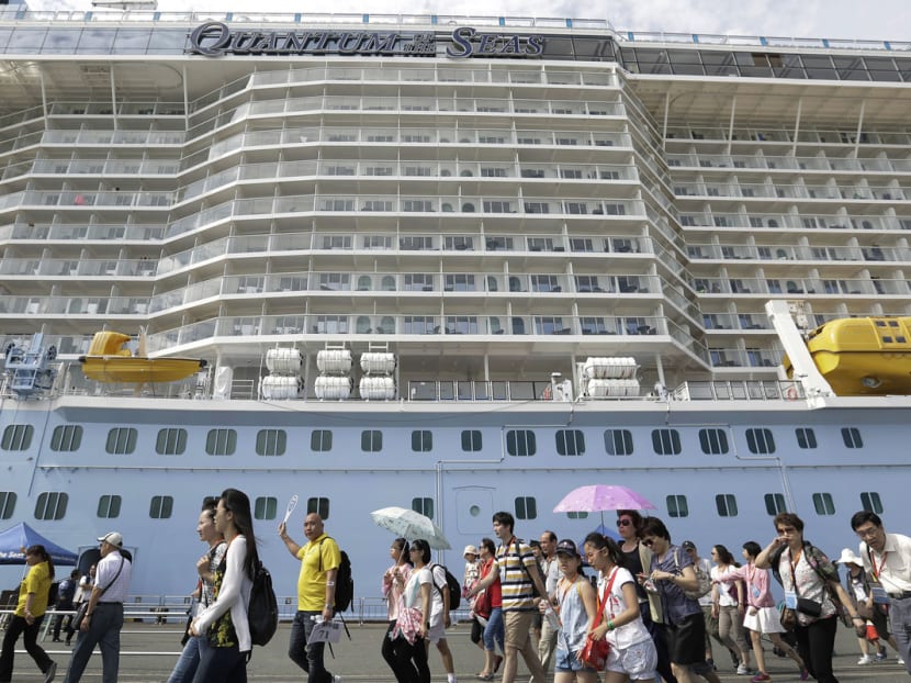 Chinese tourists walk along a pier after disembarking the Quantum of the Seas cruise ship, operated by Royal Caribbean Cruises's cruise line brand Royal Caribbean International (RCI), at the Port of Hakata in Fukuoka, Japan. Photo: Bloomberg