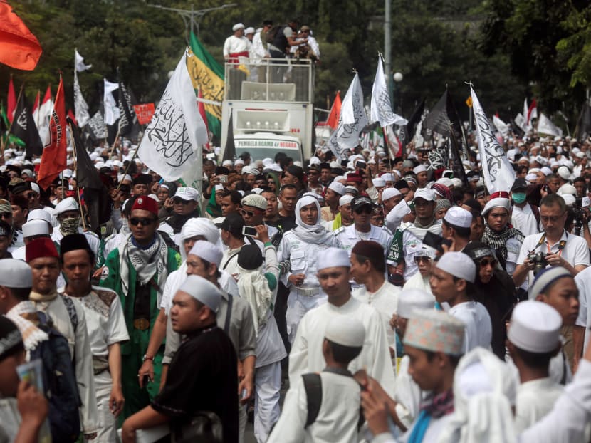 Indonesia hardline Muslim group members protest in Jakarta to call for maximum punishment to be imposed on then Jakarta governor Basuki "Ahok" Tjahaja Purnama ahead of the verdict of a blasphemy trial in May  2017.