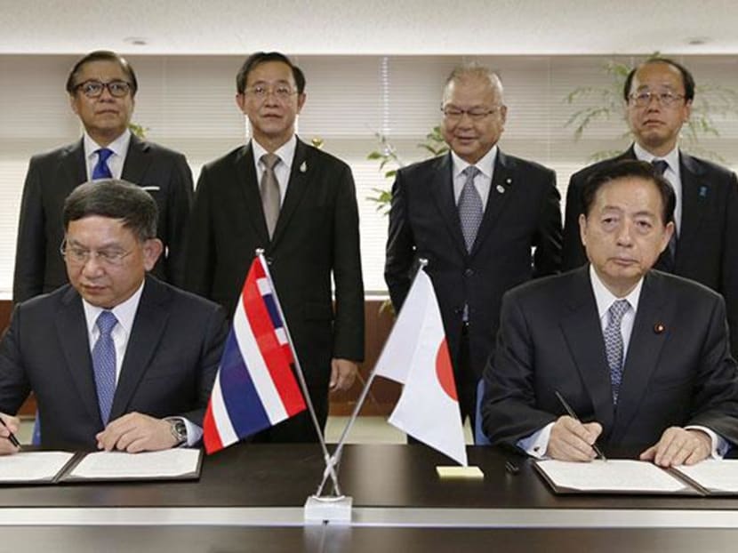Transport Minister Mr Prajin Juntong and his Japanese counterpart Mr Akihiro Ota sign a memorandum of understanding to cooperate on potential introduction of Japan's bullet-train technology in Thailand. Photo: Kyodo News