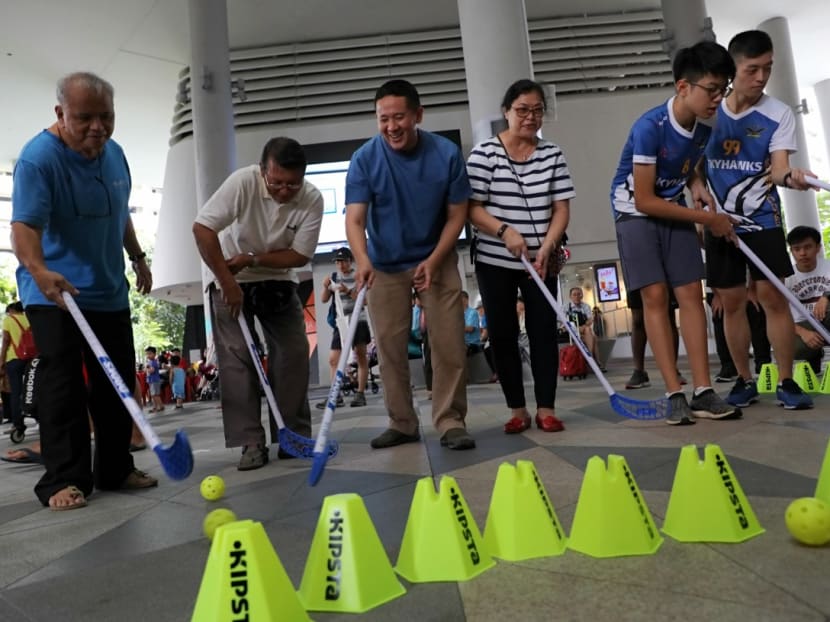 Mr Amrin Amin, Senior Parliamentary Secretary for Ministry of Health and Home Affairs and Advisor to Woodlands Grassroots Organisations (GROs), playing floorball with some seniors during the launch of Woodlands Dementia-Friendly Community (DFC) at Kampung Admiralty on Sunday (Nov 24). Photo: Nuria Ling/TODAY