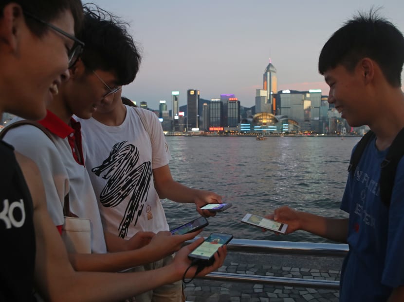 Fans maneuver their smartphones as they play "Pokemon Go" in Hong Kong, Monday, July 25, 2016. Photo: AP