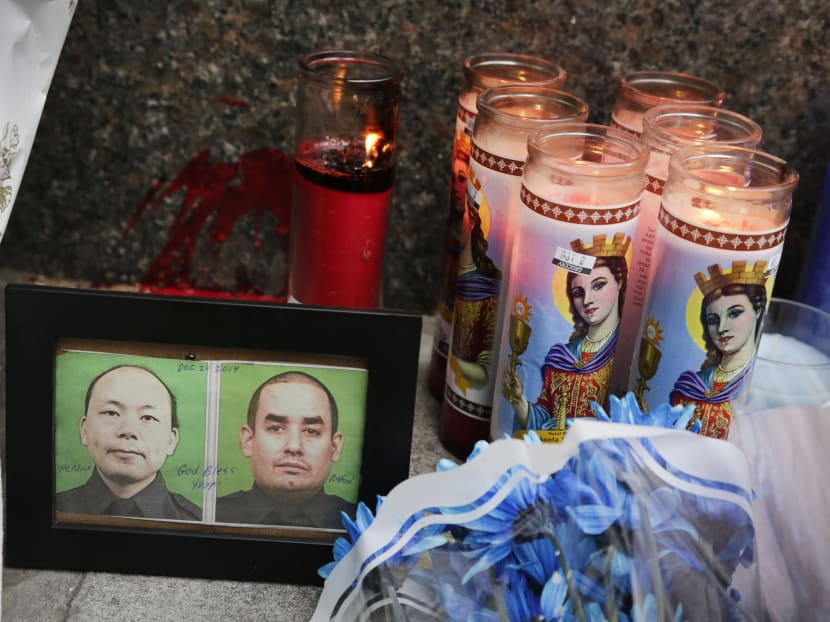 Photographs of slain New York Police officers Wenjian Liu (left) and Rafael Ramos are placed in a makeshift memorial honoring the men at the 84th Precinct in the Brooklyn borough of New York. Photo: AP