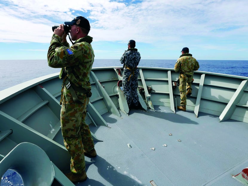 Australian sailors on HMAS Perth looking for debris from the missing Malaysia Airlines Flight MH370. Photo: Reuters