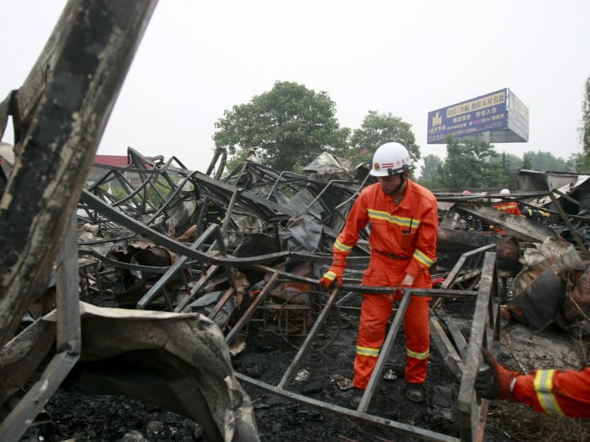 Firefighters clean up the debris after a fire at a rehabilitation centre for the elderly in Sanlihe village of Pingdingshan, Henan province, China, May 26, 2015. Photo: Reuters