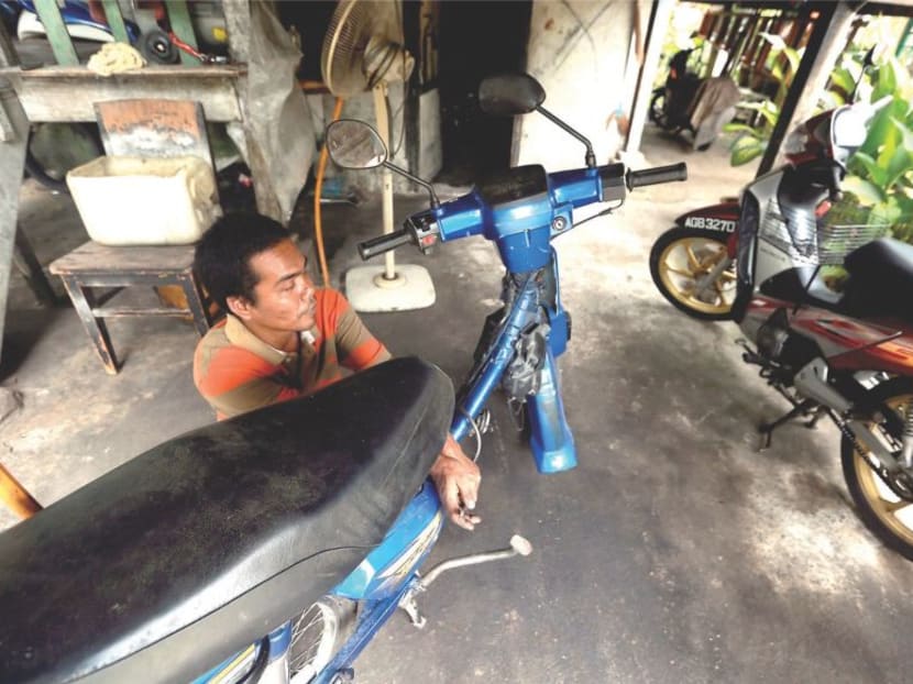 Mechanic Azhar Ibrahim working on a motorcycle in his workshop: Photo: Malay Mail Online