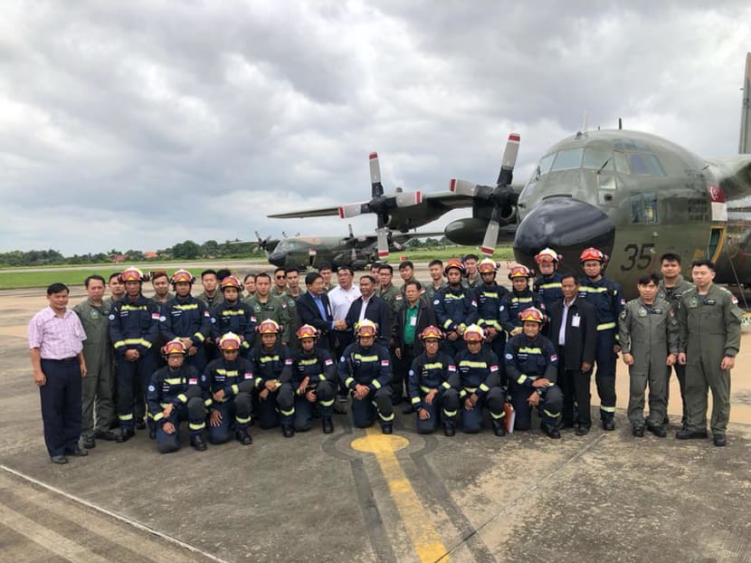 The 17-member SCDF contingent assisting in the flood relief effort pose for a photo with Singapore's ambassador to Laos, Mr Dominic Goh, after their arrival at Pakse International Airport.