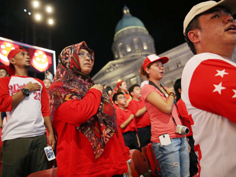 Singaporeans taking the pledge during a National Day Parade segment at the Padang. TODAY file photo