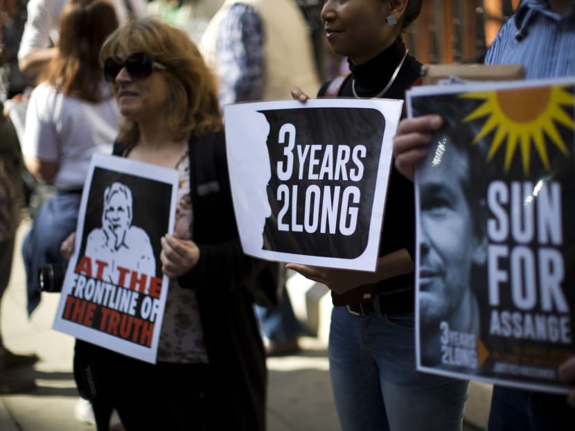 Supporters of WikiLeaks founder Julian Assange hold placards during a vigil across the street from the Ecuador embassy in London, Friday, June 19, 2015. Photo: AP