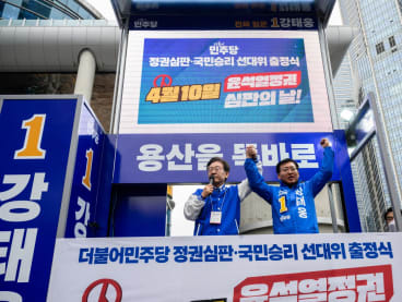 South Korea's main opposition Democratic Party of Korea leader Lee Jae-myung (left) and candidate Kang Tae-woong speak to supporters during a campaign event for the upcoming parliamentary elections in Seoul on March 28, 2024. 