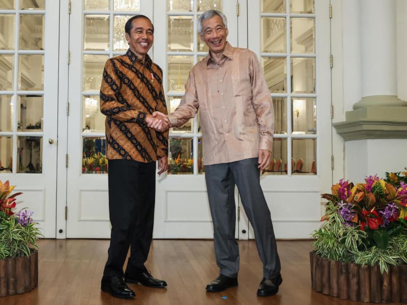 Singapore's Prime Minister Lee Hsien Loong (right) shaking hands with Indonesia's President Joko Widodo (left) as they meet at the Istana in Singapore on March 16, 2023.