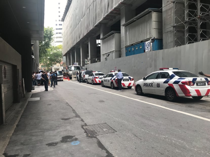 Police officers were seen talking to more than 30 foreign workers at the site of the old Central Provident Fund building in the Central Business District on March 6, 2019.