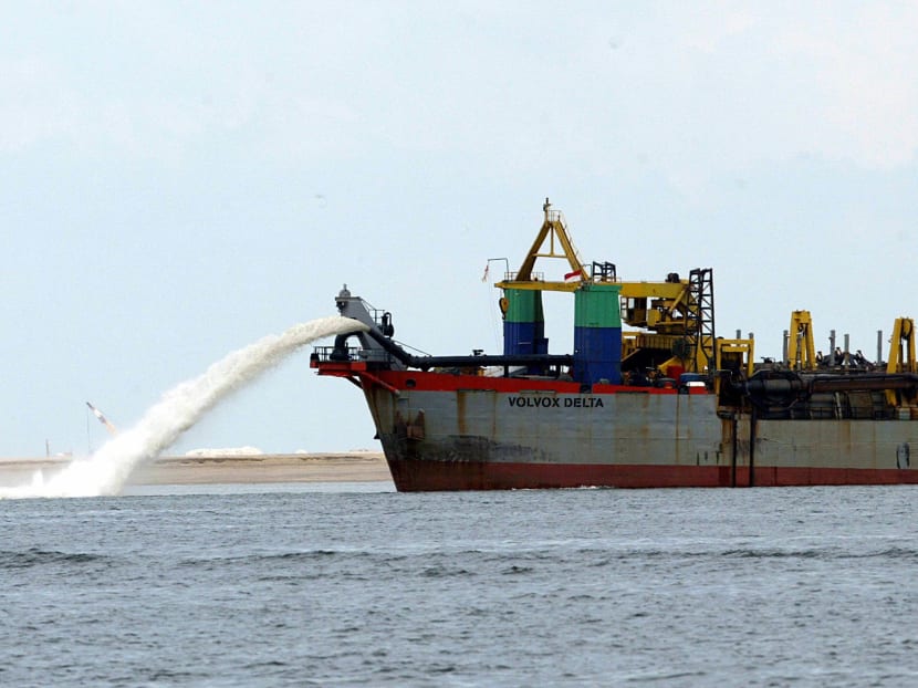 A dredger vessel spewing sands to fill the seabed for reclamation off western Singapore.  Photo: AFP