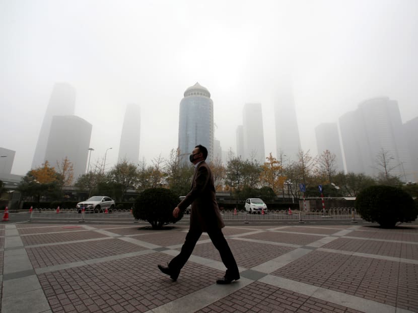 Photo of the day: A man wearing a mask walks in the central business district on a polluted day after a yellow alert was issued for smog, in Beijing, China on Wednesday, November 14, 2018.